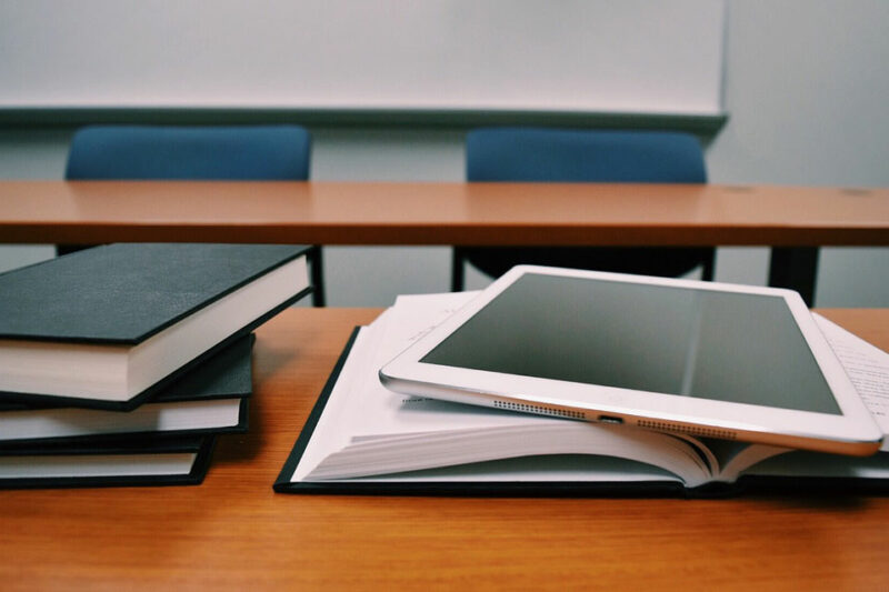Tablet und Bücher auf einer Bank
