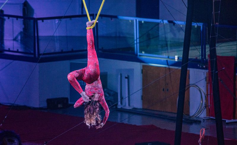 Acrobat hanging upside in the circus