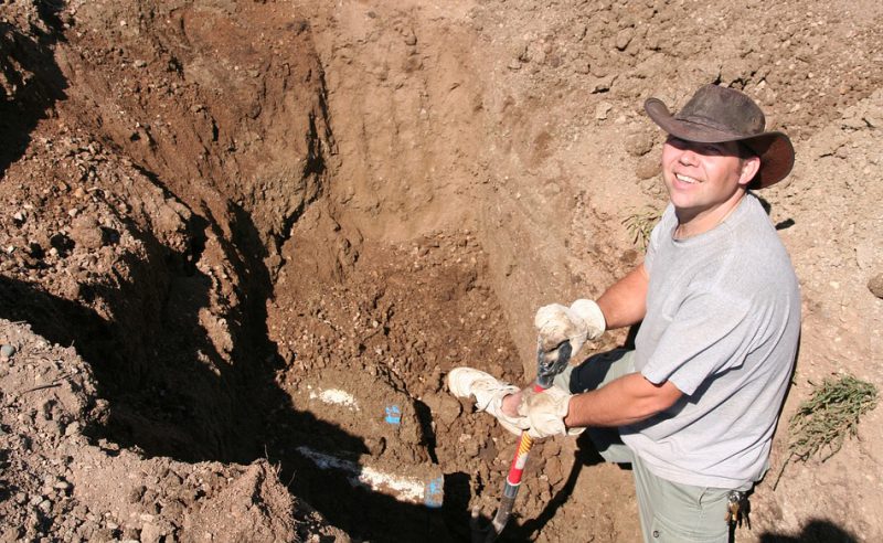 Guy digging dirt with a showel