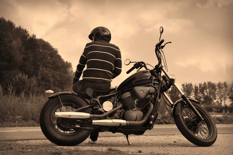 Guy sitting on parked motorcycle