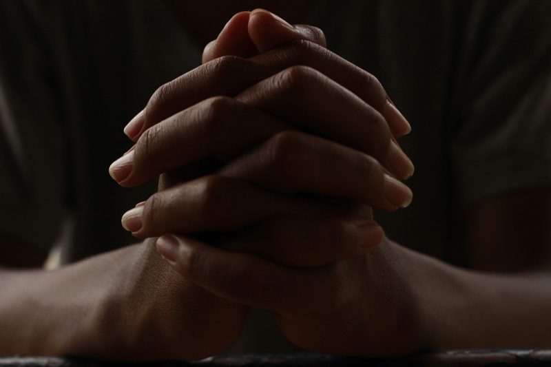 Person holding hands and praying