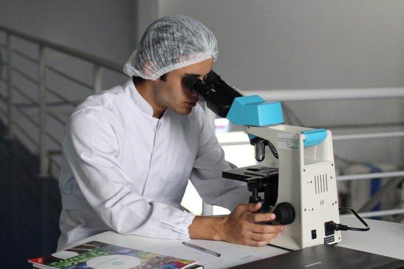 Scientist using microscope