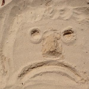 Sad smiley in the sand