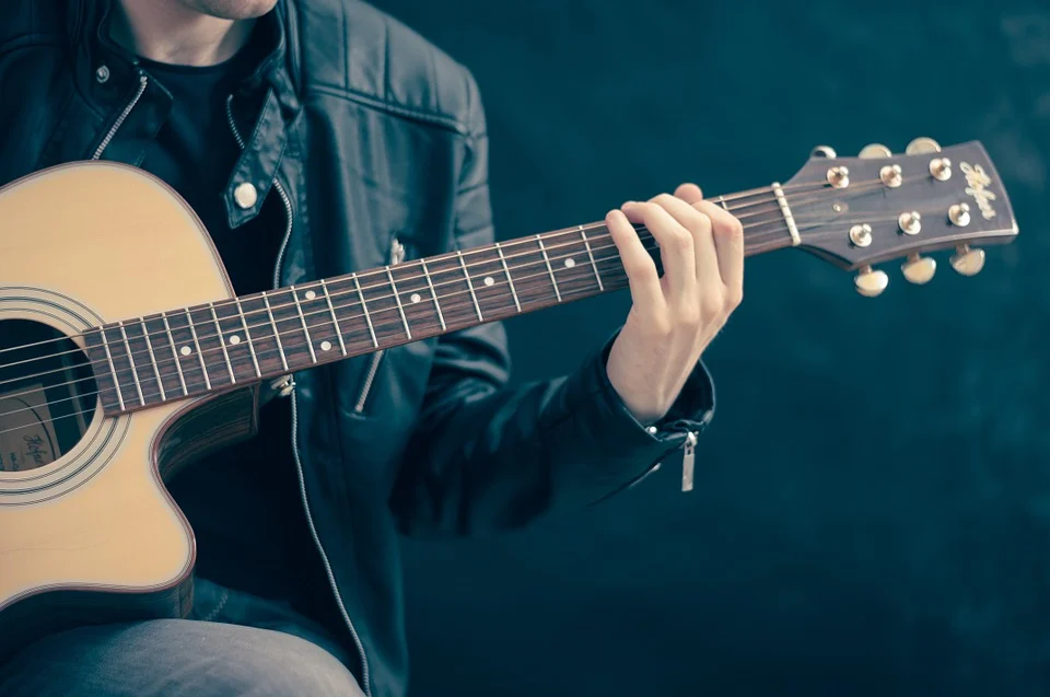 A person is holding a guitar and playing