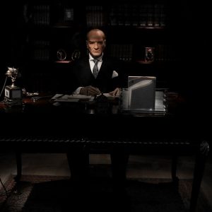 The officer sits in a darkened office