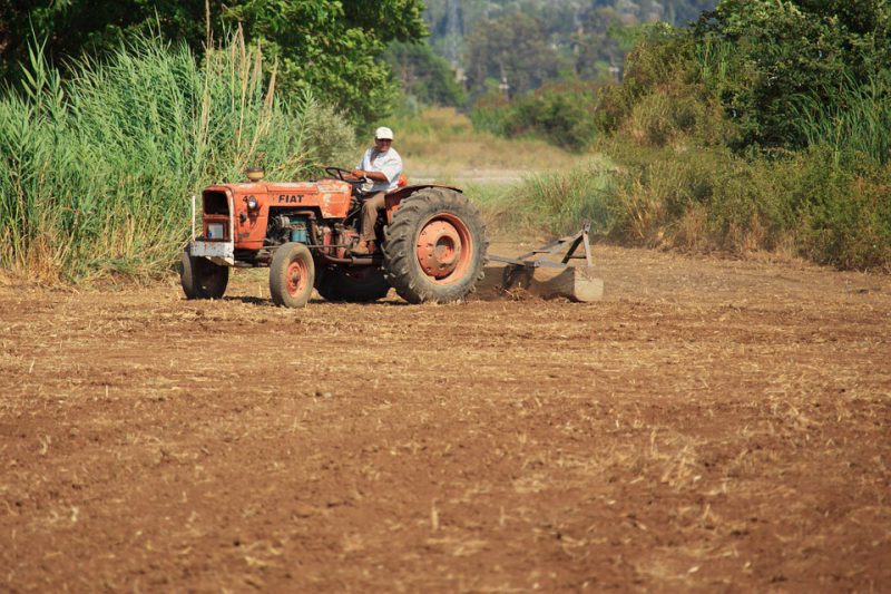 A man plows the land with a tractor
