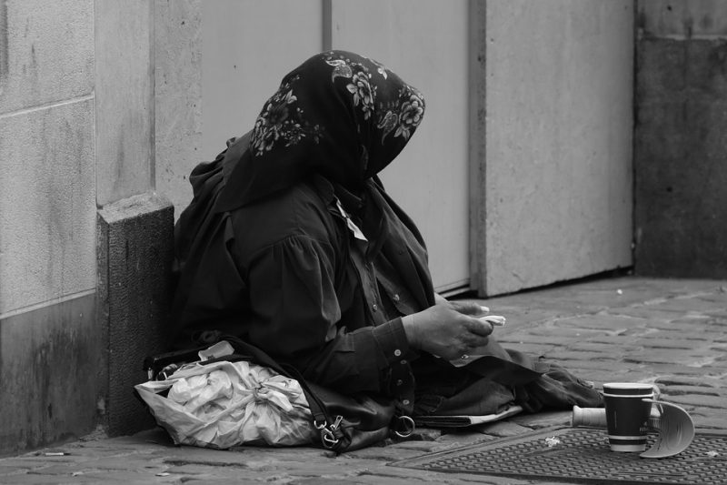 A beggar is sitting on the street