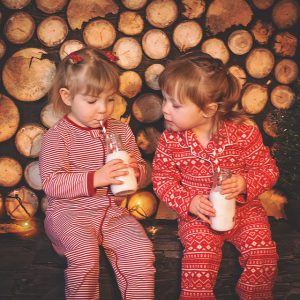 Little girls in pajamas drink milk