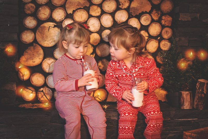 Little girls in pajamas drink milk