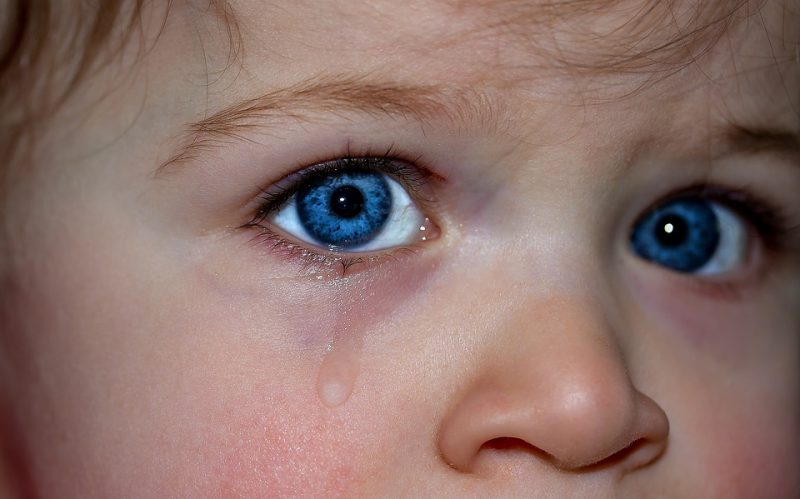 The blue-eyed child is crying