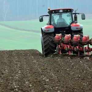 A man plows the land with a tractor