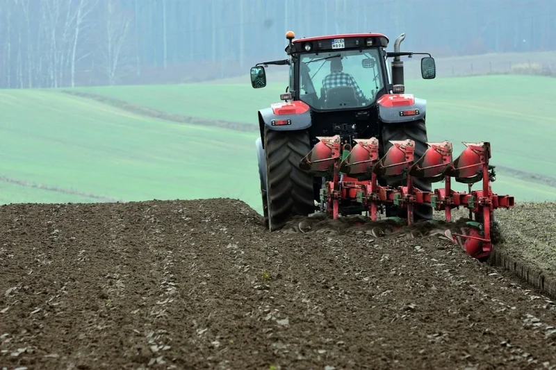 A man plows the land with a tractor