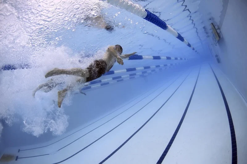 A man is swimming in a pool