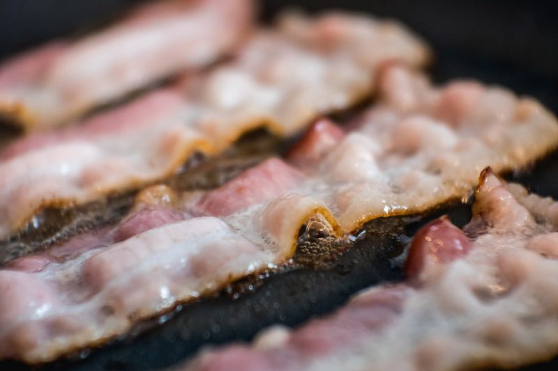 Bacon is fried in a pan