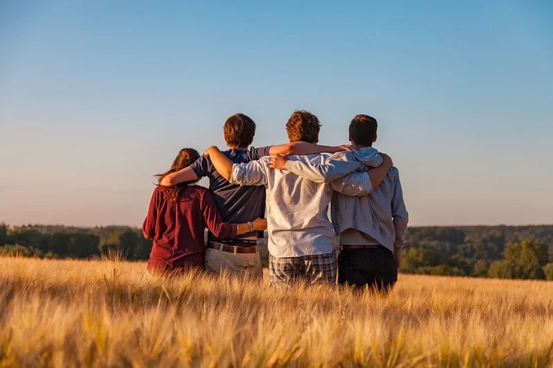 Friends in each other's arms look into the distance