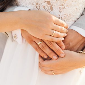 Couple with wedding rings in each other's arms