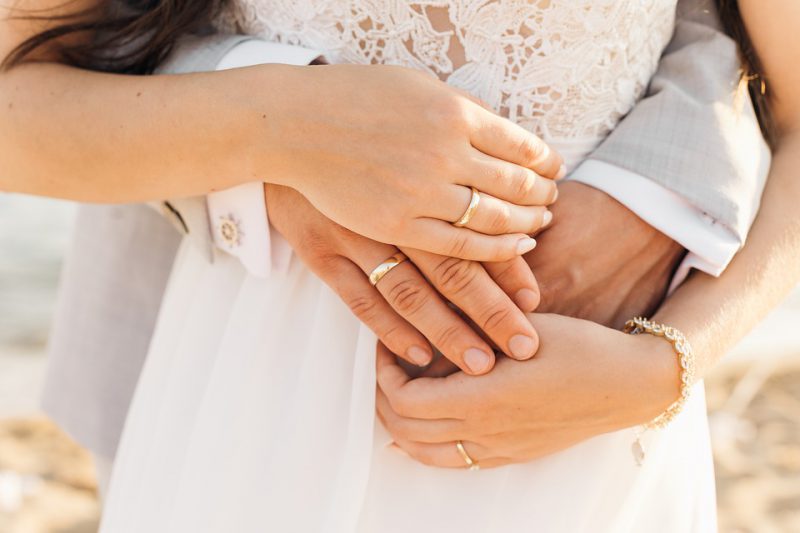 Couple with wedding rings in each other's arms