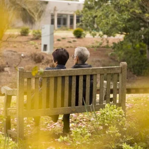 Two women are sitting on a bench and talking