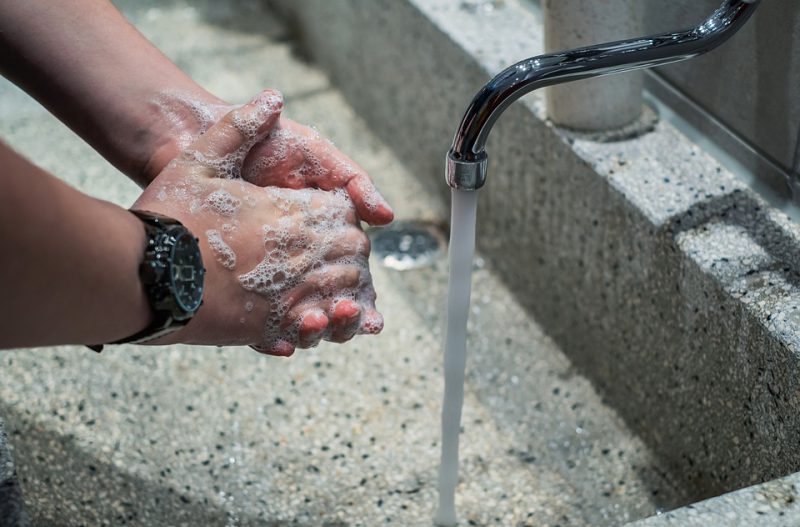 A person washes his hands