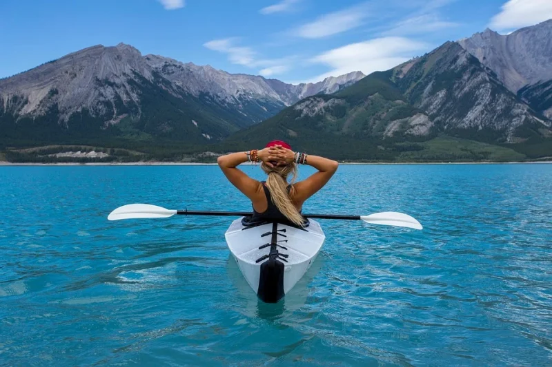 A woman in a kayak with a view of the mountains