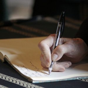 A person writes something in a notebook