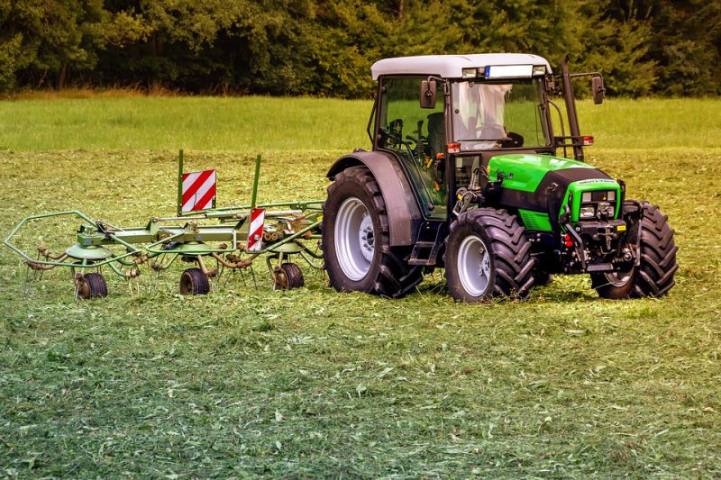 Tractor in the field with auxiliary attachment