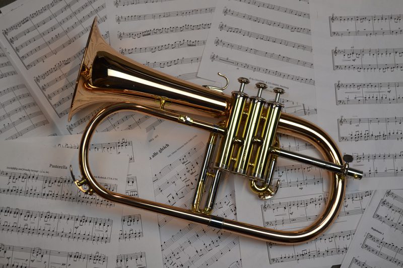 Trumpet with music letters below it