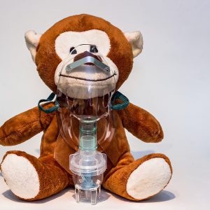 A stuffed monkey with an oxygen mask