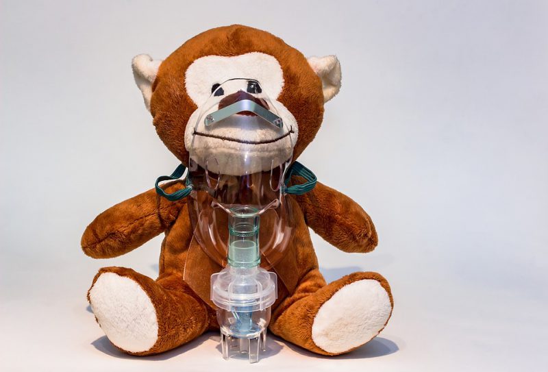 A stuffed monkey with an oxygen mask