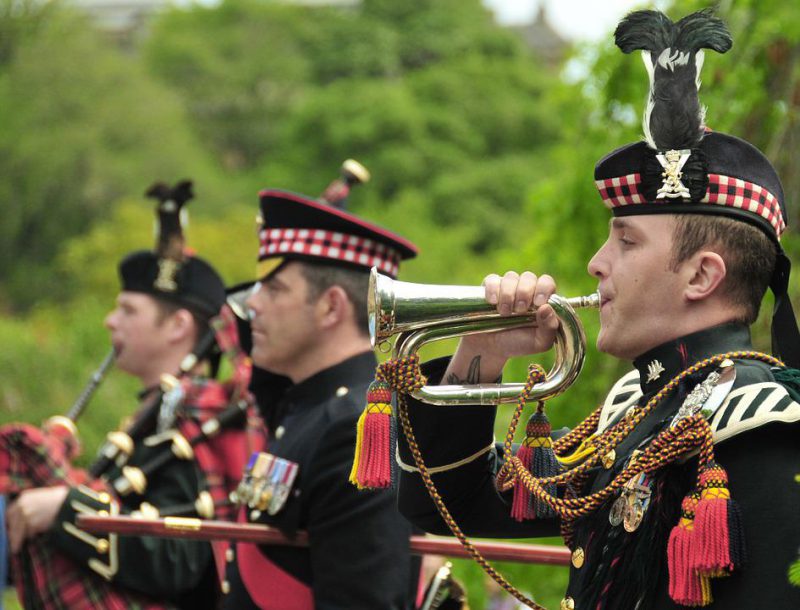 A man in a parade holds a bugle
