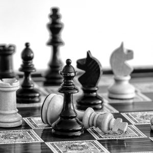 A chessboard and several pieces with a knocked down white king