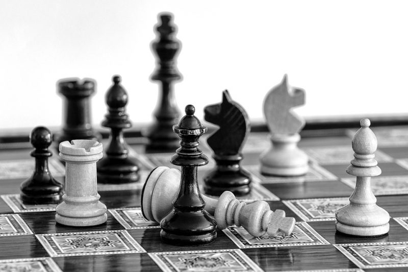 A chessboard and several pieces with a knocked down white king