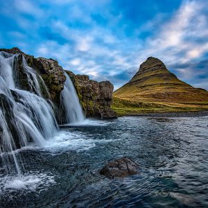 A waterfall landscape with a solitary mountain in the background