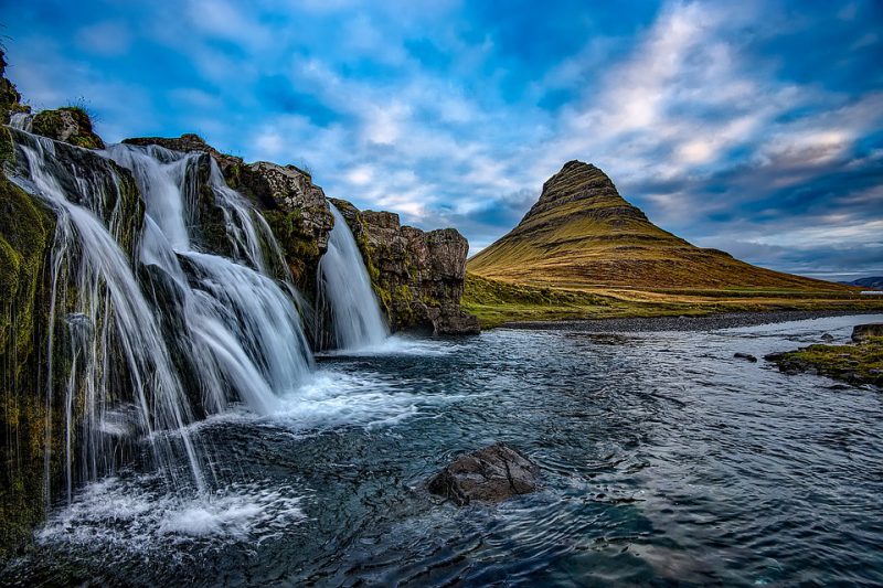A waterfall landscape with a solitary mountain in the background