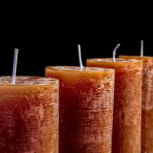 Four candles lined up in a row with a black background