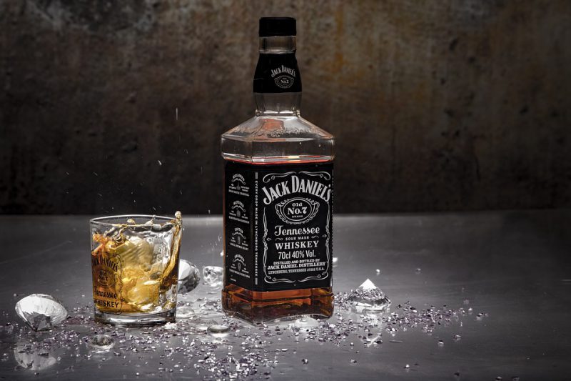 A bottle of Jack Daniels served in a glass with diamonds beneath it