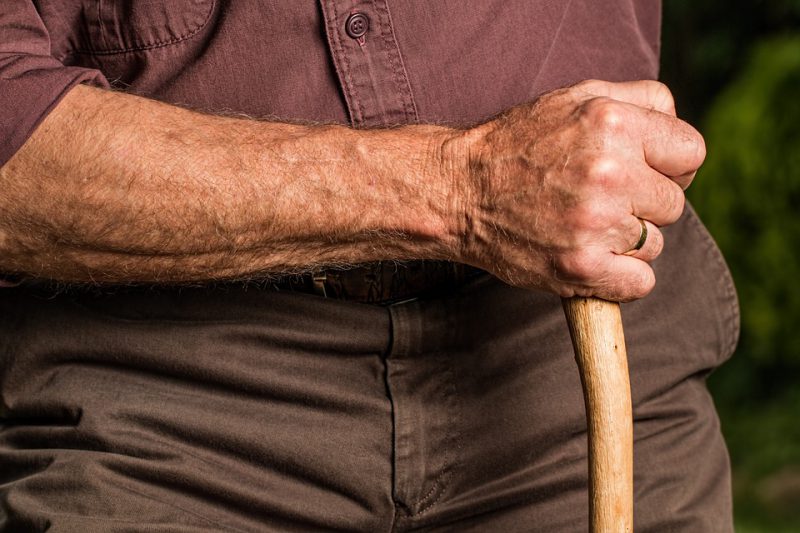 A man's hand holds a wooden stick