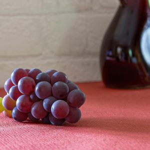 Blue grapes on a red surface