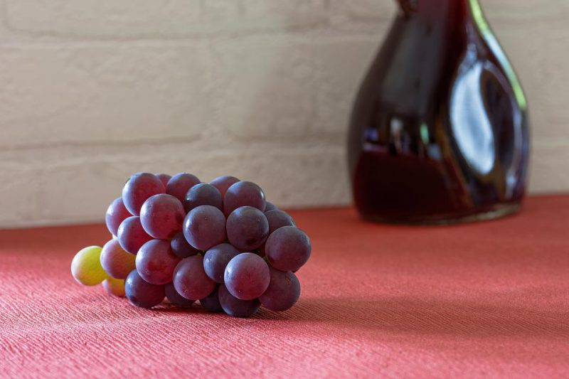 Blue grapes on a red surface