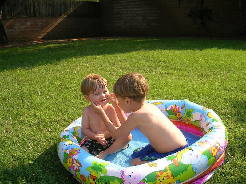 Children play in a small inflatable pool