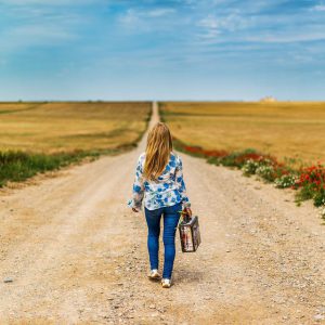 A woman walks on a field road