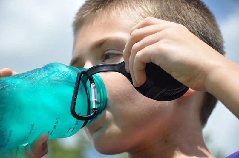 Boy drinking from a plastic bottle