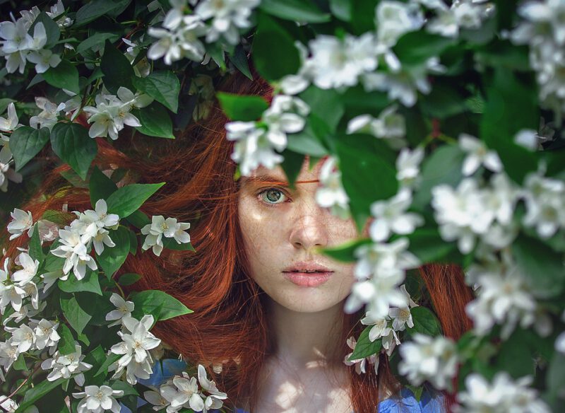 Girl peaking through leaves