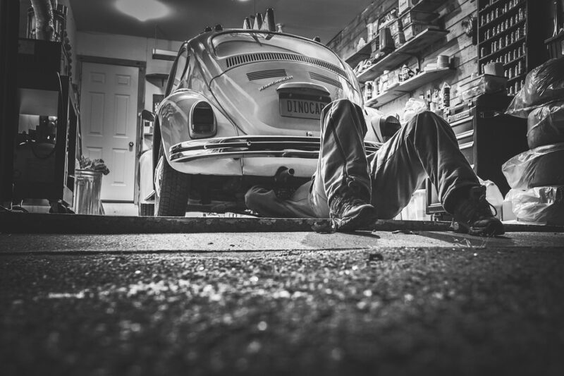 Mechanic fixing old VW Beetle